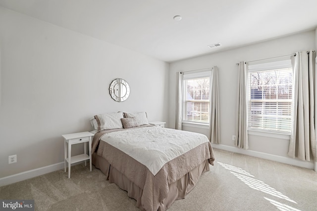 bedroom featuring baseboards, visible vents, and light colored carpet