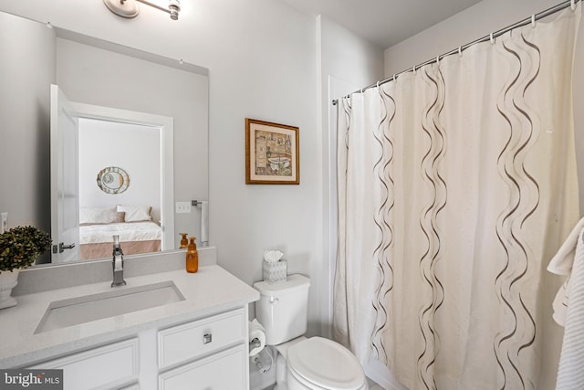 ensuite bathroom with connected bathroom, vanity, and toilet