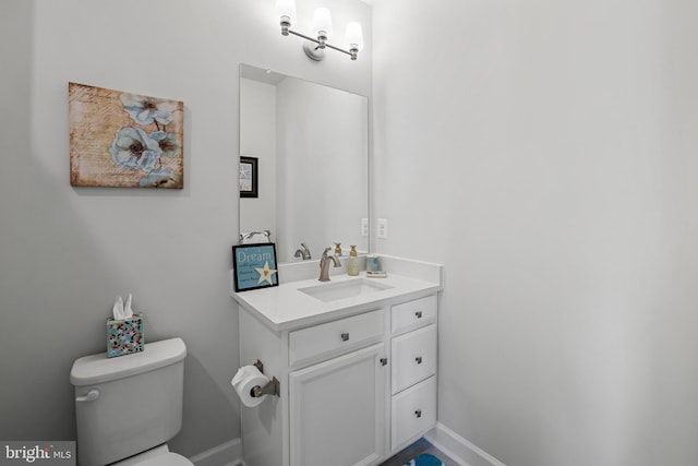 bathroom with vanity, toilet, and baseboards