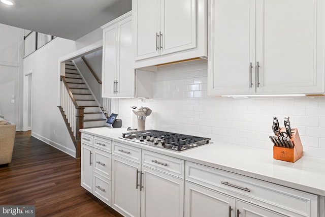 kitchen with stainless steel gas stovetop, white cabinetry, dark wood finished floors, and light countertops