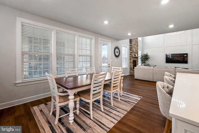 dining room with dark wood-style floors, recessed lighting, a fireplace, and baseboards