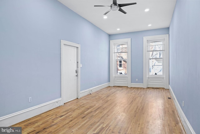 empty room with baseboards, wood finished floors, a ceiling fan, and recessed lighting