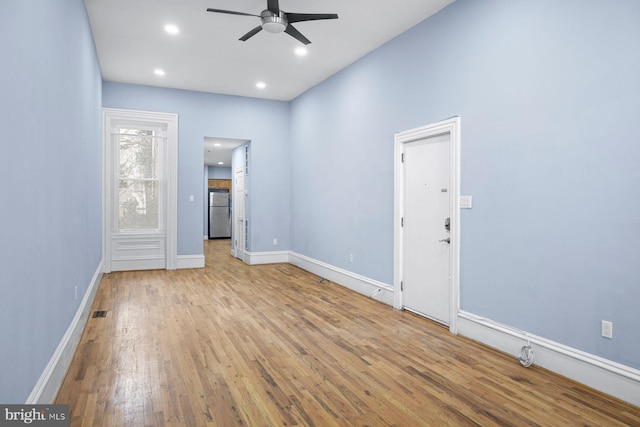 empty room with ceiling fan, recessed lighting, wood finished floors, and baseboards