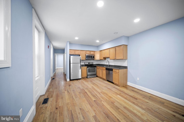 kitchen with light wood-style flooring, visible vents, baseboards, appliances with stainless steel finishes, and dark countertops