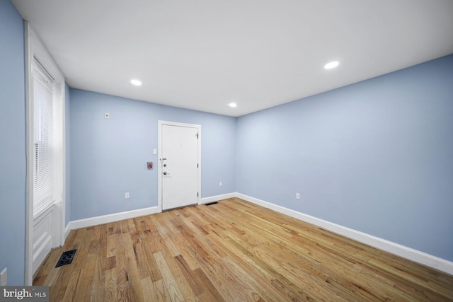 empty room with light wood-type flooring, baseboards, visible vents, and recessed lighting