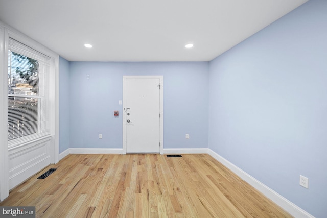 empty room featuring recessed lighting, light wood-type flooring, visible vents, and baseboards