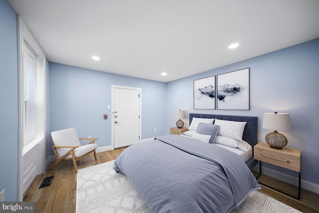 bedroom with recessed lighting, visible vents, baseboards, and wood finished floors