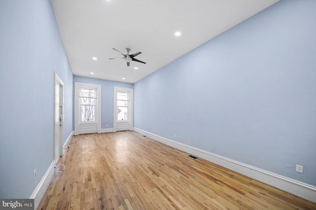 unfurnished room with light wood-style floors, recessed lighting, visible vents, and baseboards