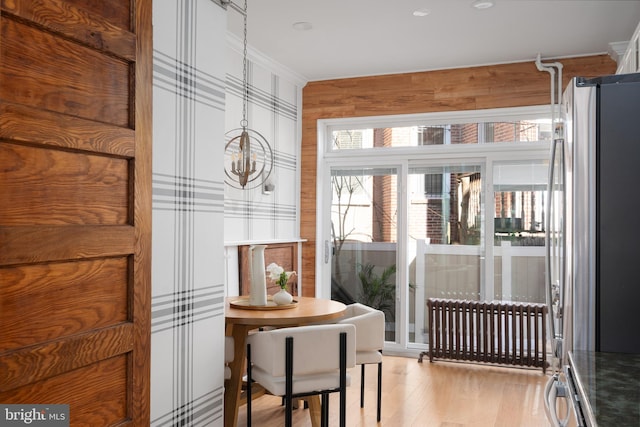 sunroom / solarium with radiator and a chandelier