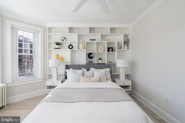 bedroom with baseboards, a ceiling fan, radiator heating unit, ornamental molding, and wood finished floors