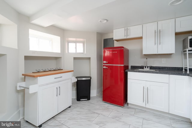 kitchen featuring a sink, white cabinetry, marble finish floor, freestanding refrigerator, and dark countertops