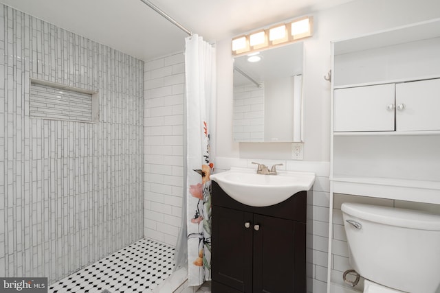 bathroom featuring toilet, a shower stall, and vanity