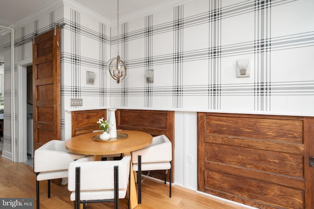 dining space featuring light wood-style flooring and crown molding