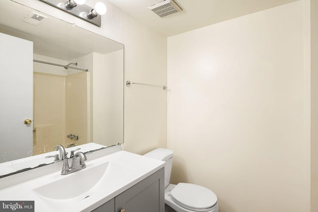 bathroom with visible vents, toilet, vanity, and walk in shower