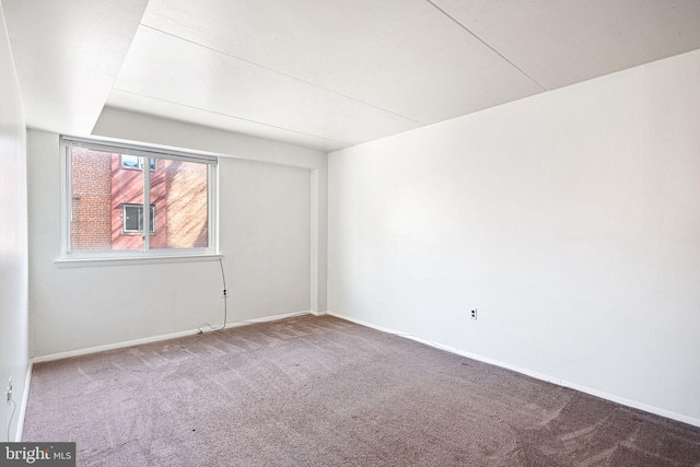 spare room featuring carpet flooring and baseboards