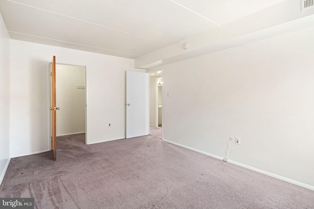 unfurnished bedroom featuring carpet flooring, visible vents, and baseboards