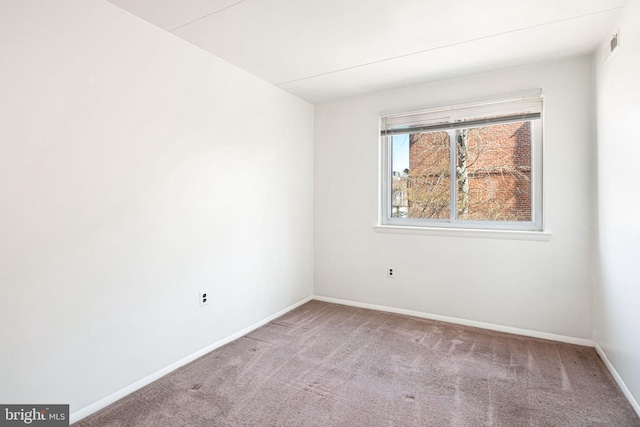 spare room featuring visible vents, baseboards, and carpet flooring