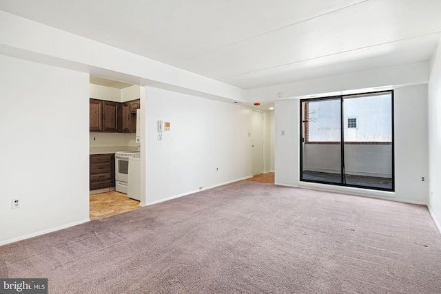 unfurnished living room featuring light colored carpet and baseboards