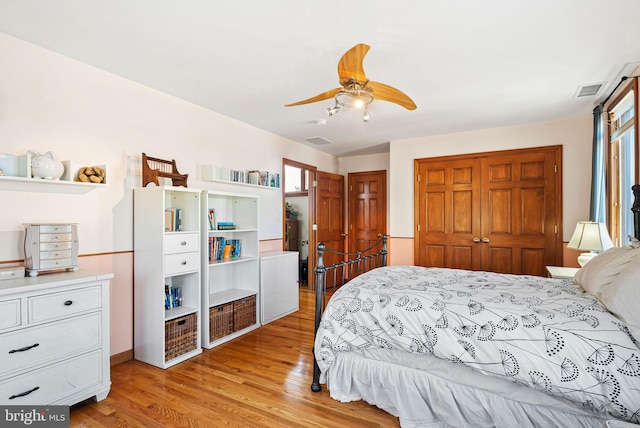 bedroom with ceiling fan, multiple windows, a closet, and light wood-style floors