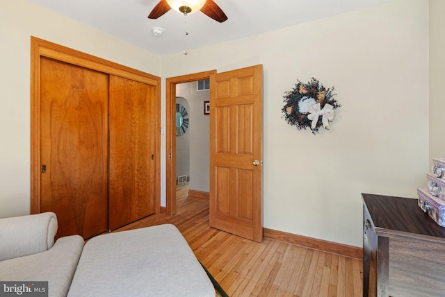 bedroom featuring light wood-style flooring, visible vents, baseboards, and a closet