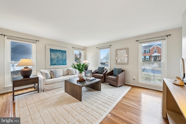 living room with baseboards, plenty of natural light, and light wood finished floors