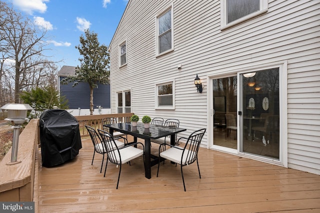 wooden deck featuring a grill and outdoor dining area