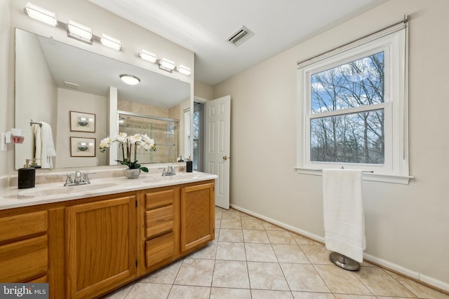 bathroom with tile patterned flooring, a sink, visible vents, a shower stall, and double vanity