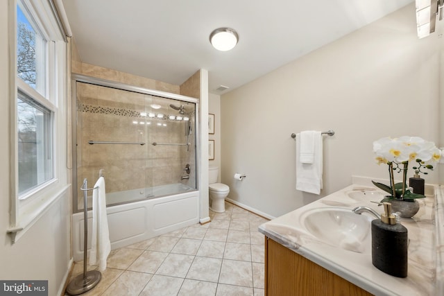 bathroom with shower / bath combination with glass door, double vanity, toilet, a sink, and tile patterned floors