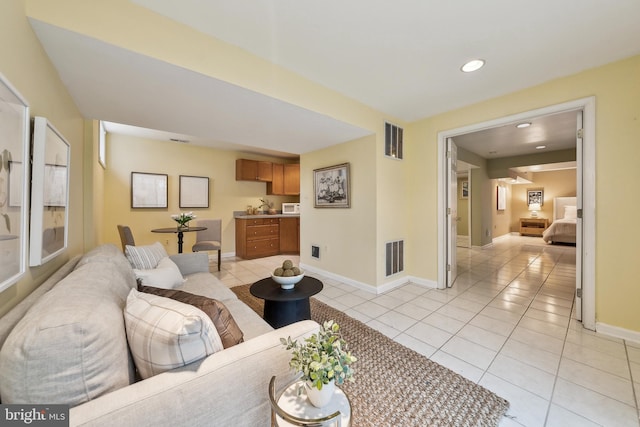 living area with light tile patterned floors, recessed lighting, visible vents, and baseboards