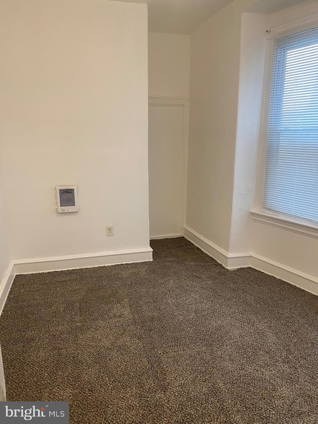 empty room featuring carpet floors and baseboards