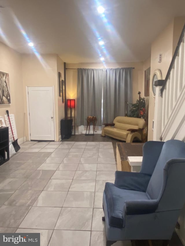 sitting room featuring stairway and light tile patterned flooring