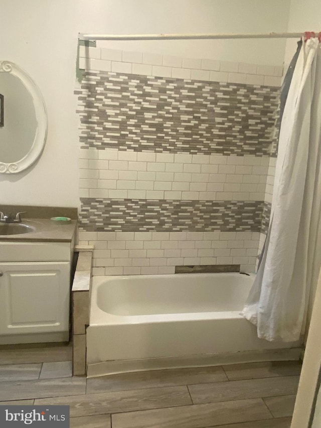 full bath with wood finish floors, vanity, and shower / bath combo with shower curtain