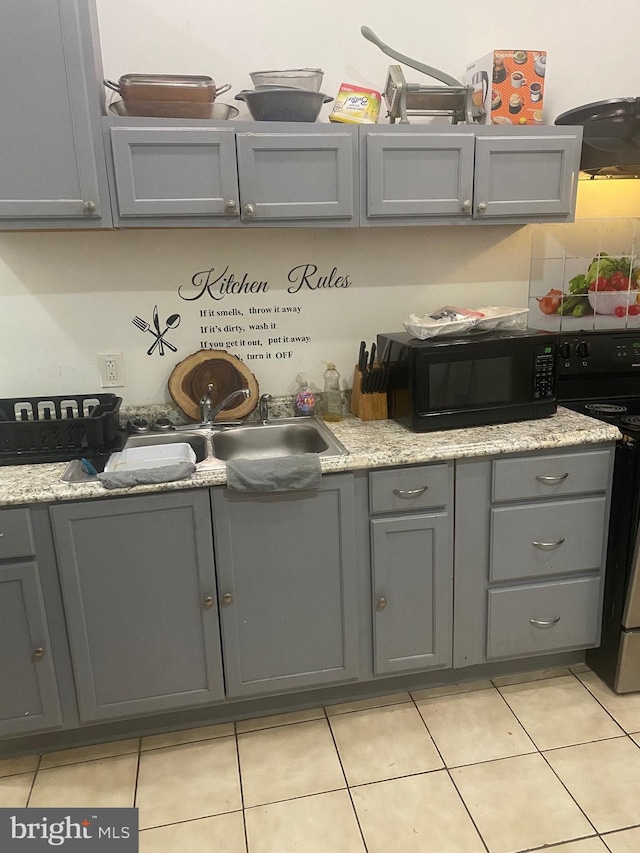 kitchen featuring black appliances, light tile patterned floors, and gray cabinets