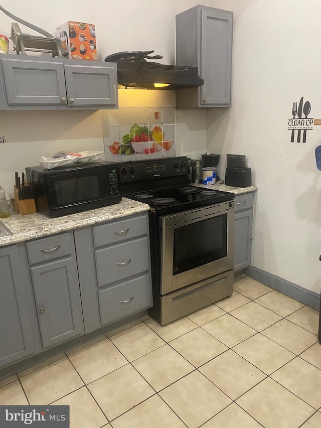 kitchen featuring tasteful backsplash, gray cabinets, stainless steel range with electric stovetop, black microwave, and baseboards