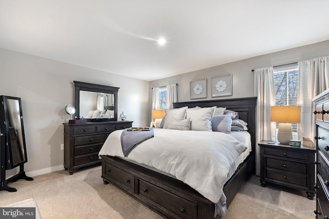 bedroom with baseboards and light colored carpet