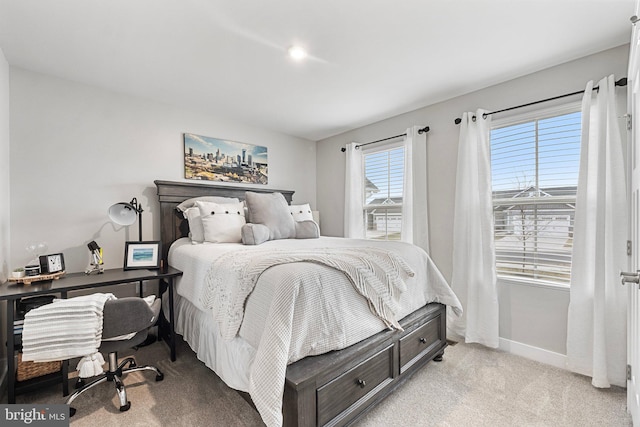 bedroom with baseboards and light colored carpet