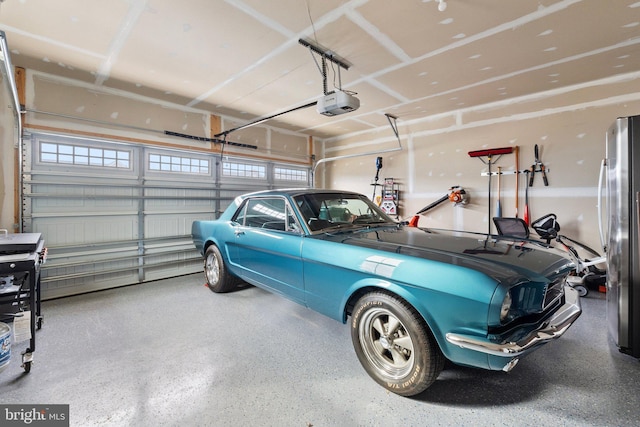 garage featuring a garage door opener and freestanding refrigerator