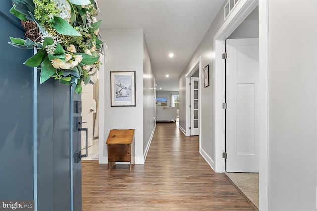 corridor with baseboards, wood finished floors, and recessed lighting