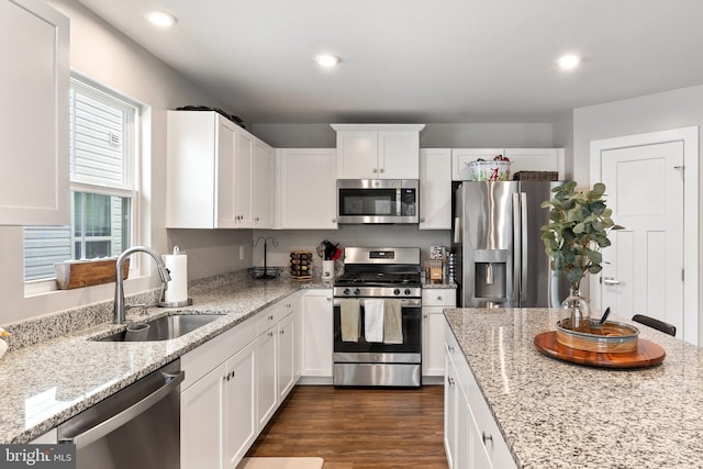 kitchen with dark wood finished floors, white cabinets, appliances with stainless steel finishes, a sink, and recessed lighting