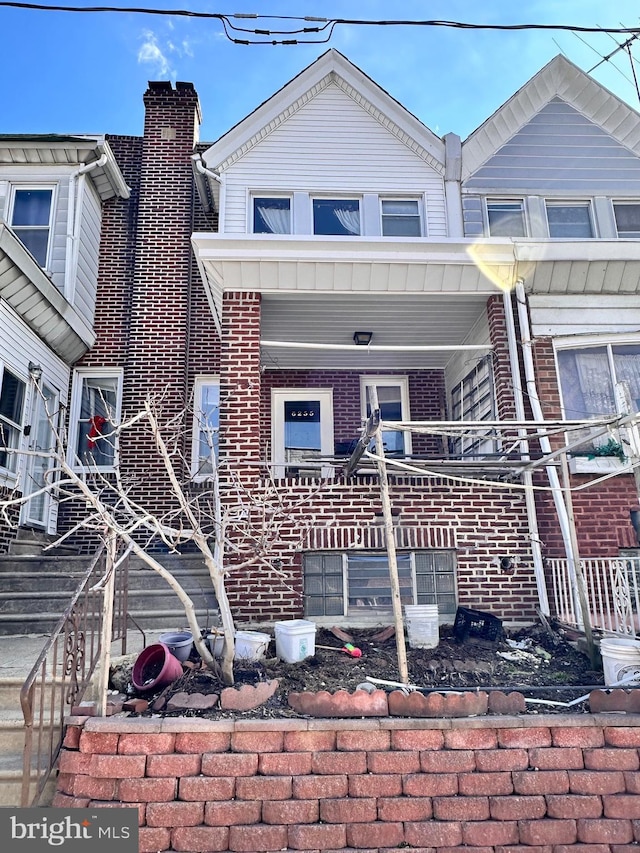 view of property with a porch and brick siding