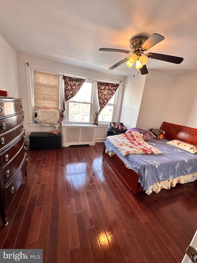 unfurnished bedroom featuring radiator, ceiling fan, and dark wood-style flooring