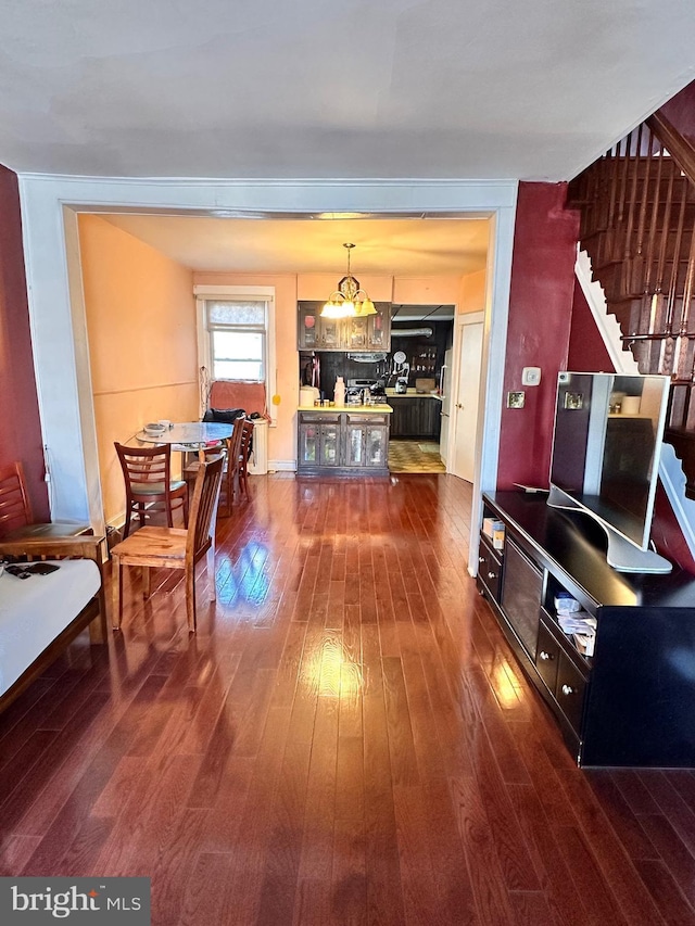 dining space featuring stairs and dark wood-type flooring