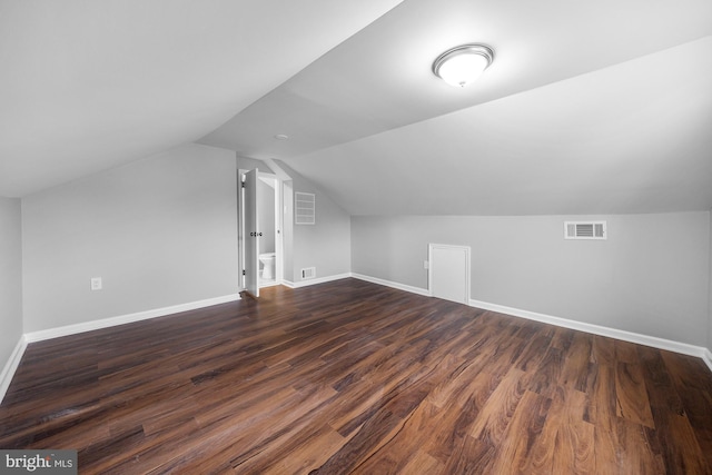 bonus room with lofted ceiling, dark wood-style flooring, visible vents, and baseboards