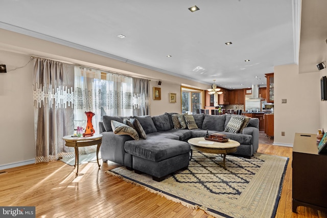 living area with baseboards, recessed lighting, and light wood-style floors