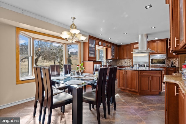 dining space featuring a healthy amount of sunlight, baseboards, a chandelier, and crown molding