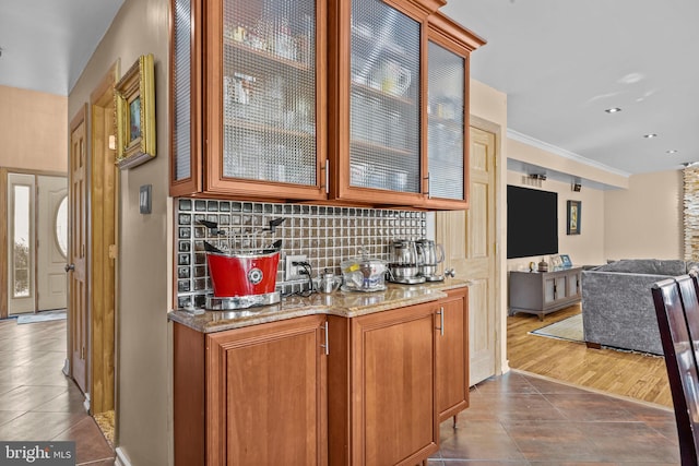 bar featuring dark tile patterned flooring and backsplash