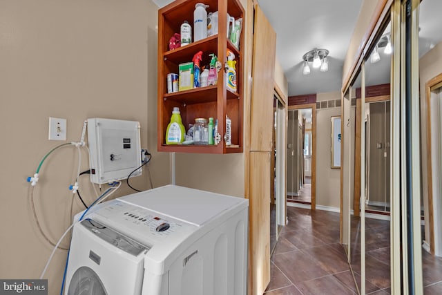 laundry area featuring washer / dryer and dark tile patterned floors