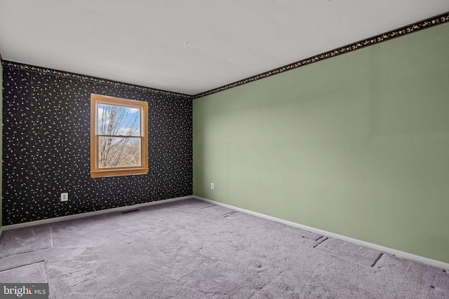 unfurnished room with baseboards and light colored carpet