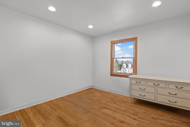 empty room featuring recessed lighting, light wood-style flooring, and baseboards