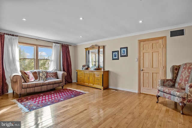 living area featuring light wood-style floors, recessed lighting, crown molding, and baseboards